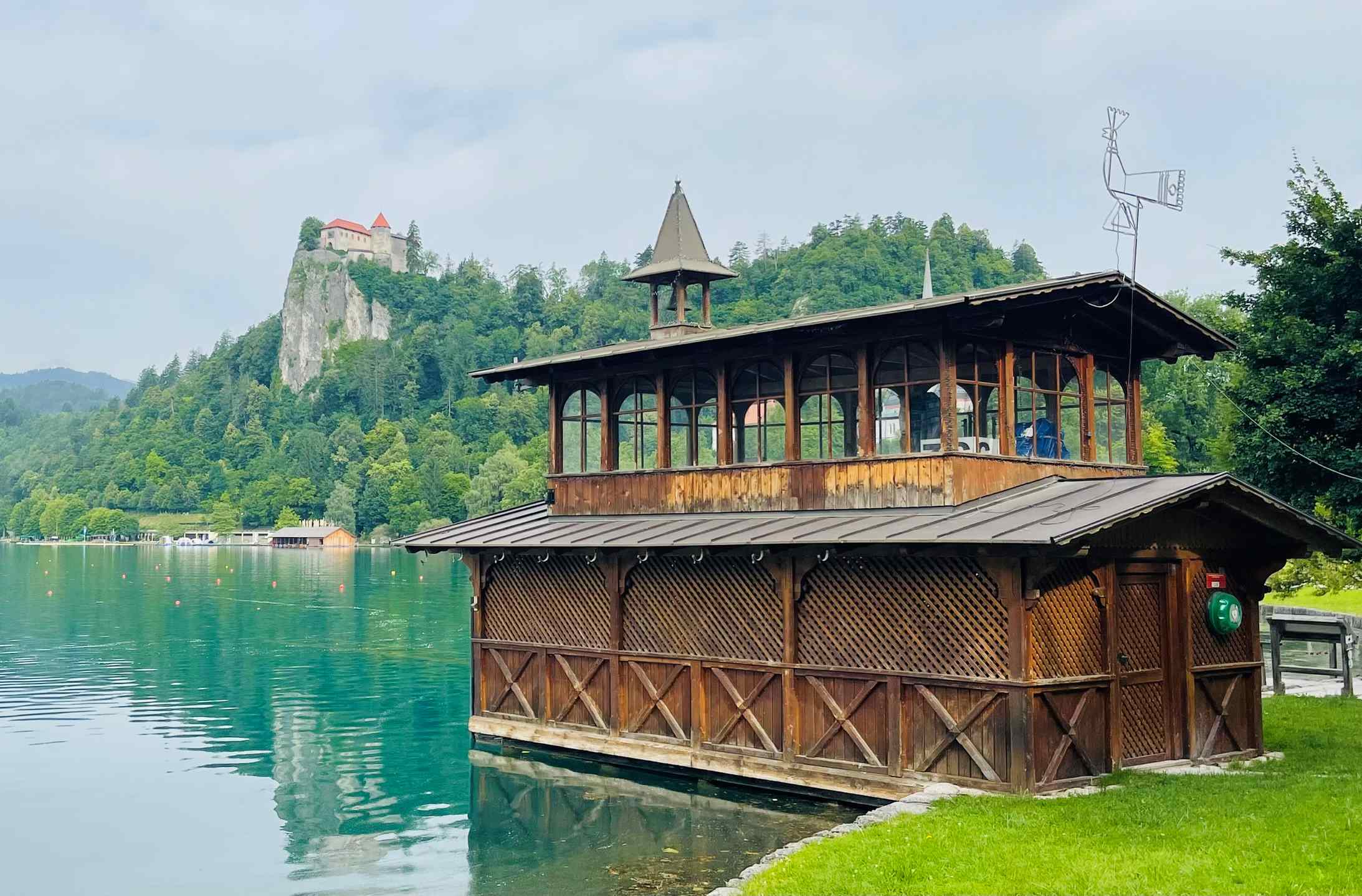 Boathouse on lake bled: trieste slovenia with hill and church in distance